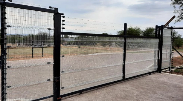 Custom steel gate design with anti-climb Clear View mesh panels, enhancing security at a commercial facility